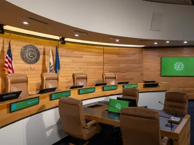 City Council chamber interior with green-colored display screens.